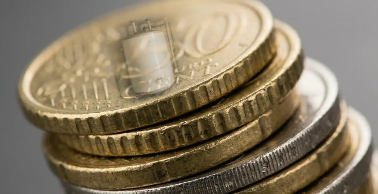 Vue macro de pièces euros empilées avec reflet d'un ballon thermodynamique