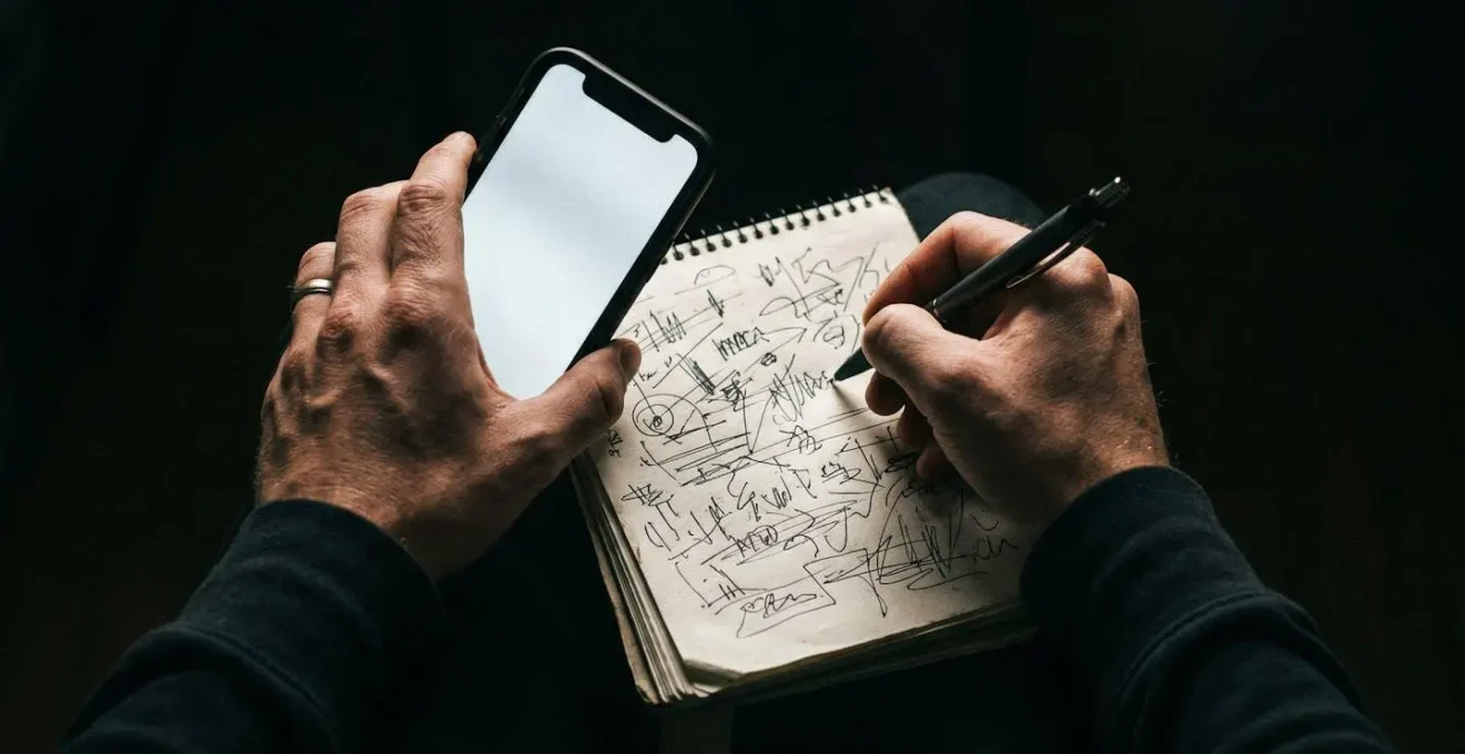Personne concentrée prenant des notes pendant un appel téléphonique d'urgence